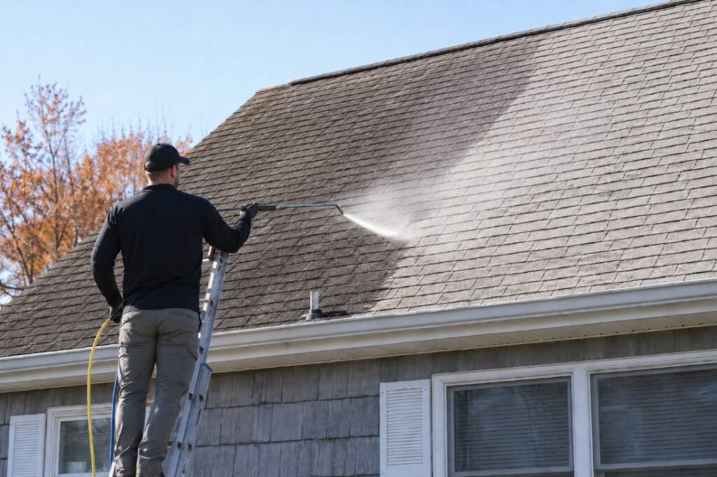 Soft washing removing black streaks from a rental property roof at the Jersey Shore in fall.